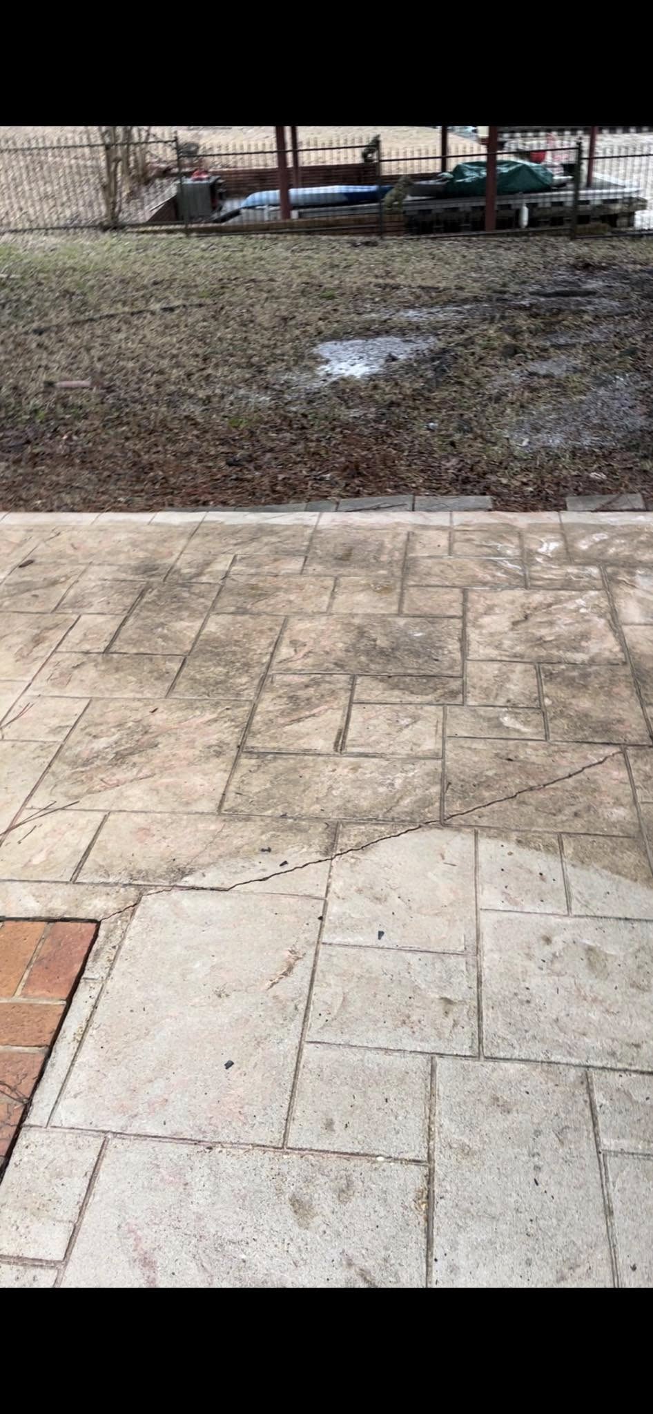Stamped concrete pool deck stained with algae before pressure washing