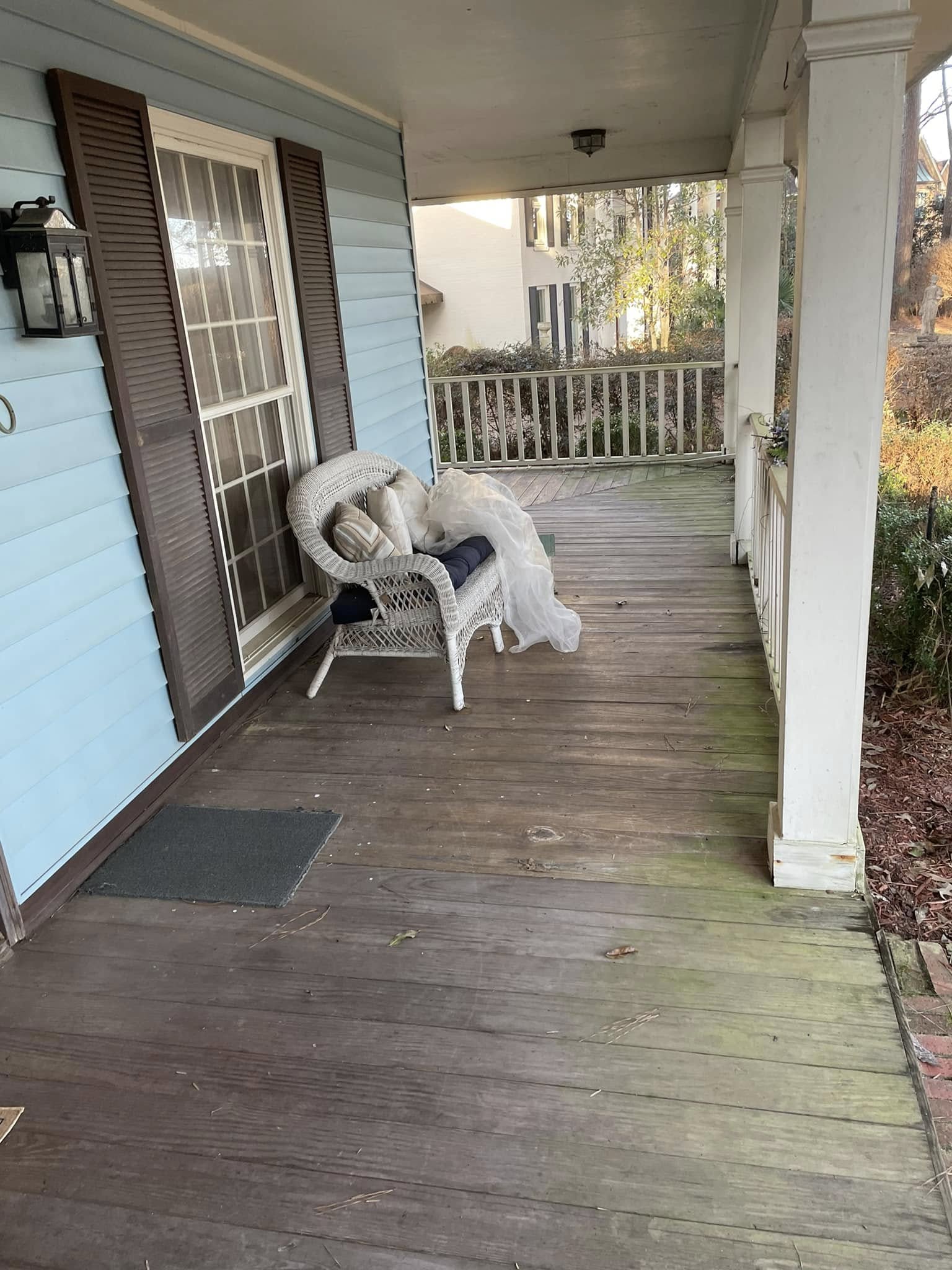 Wood porch with dirty deck boards before pressure washing